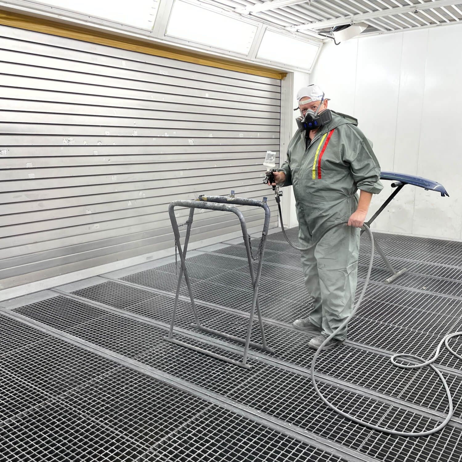 Lackierer in der Kfz-Lackierkabine